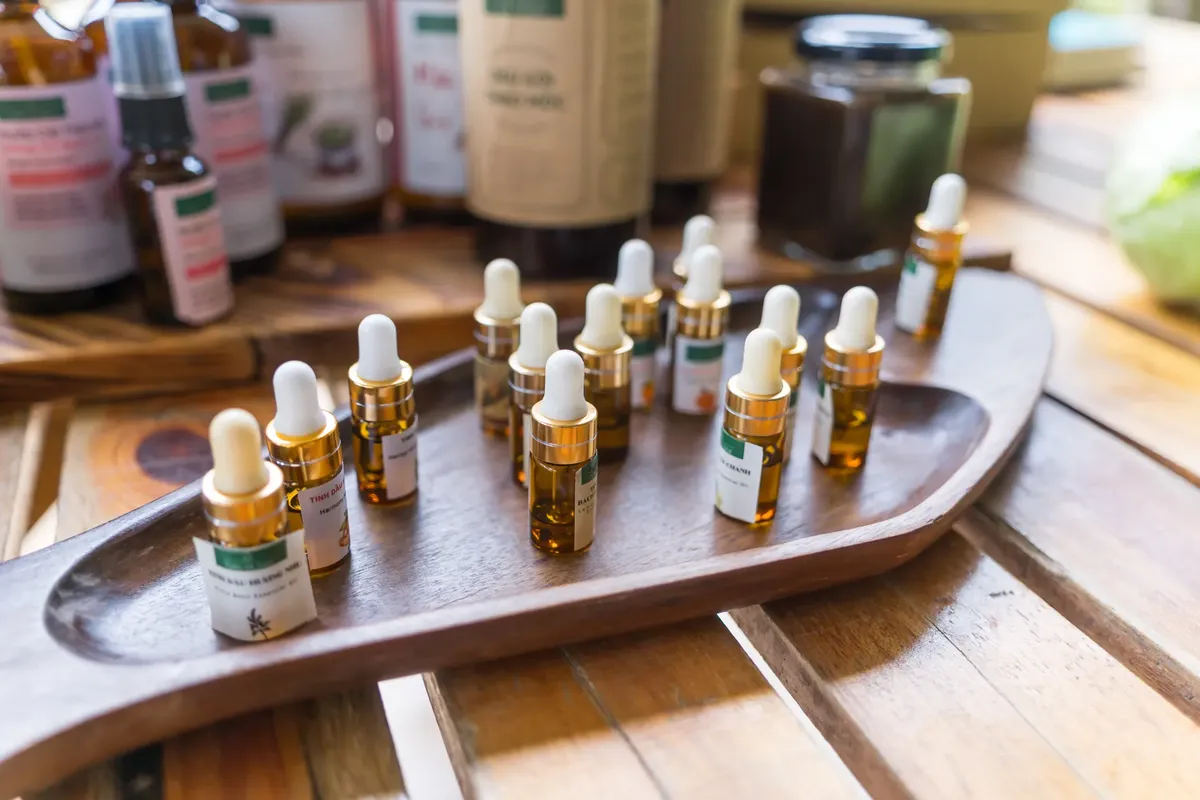 essential oil 滴瓶集合擺放在木製託盤上，周圍圍繞著自然產品。